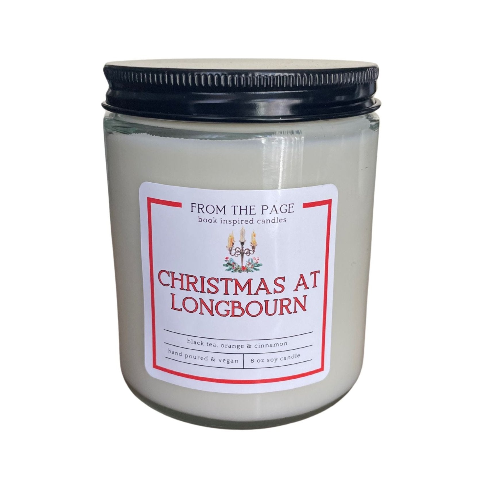 A white candle with a black lid. The label has a red border and reads 
Christmas at Longbourn, with a small photo of a candleabra and holly