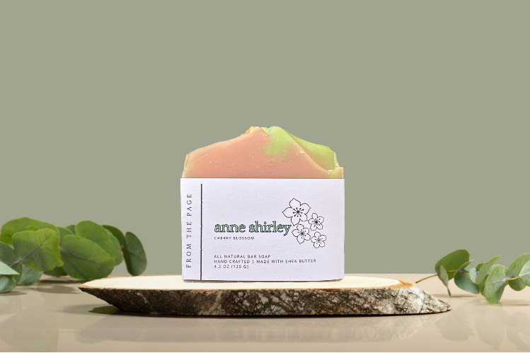 Bar of soap with a label on a stone surface against a green background with the label "Anne Shirley"